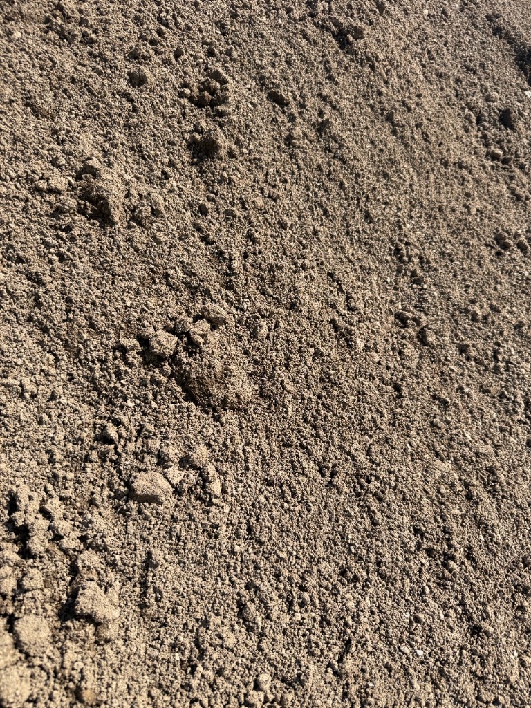 Construction sand: fine uniform tan and buff granular material.
